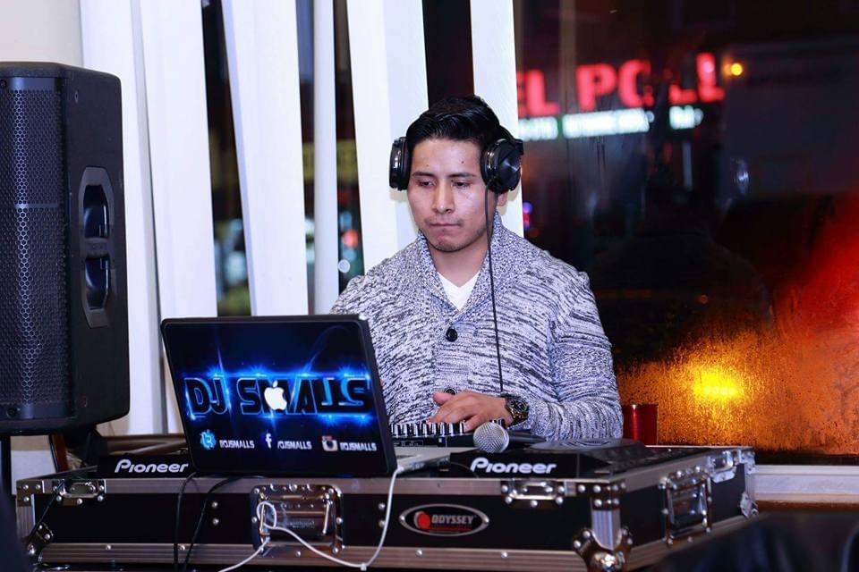 DJ Smalls con audífonos mezclando en su equipo Pioneer